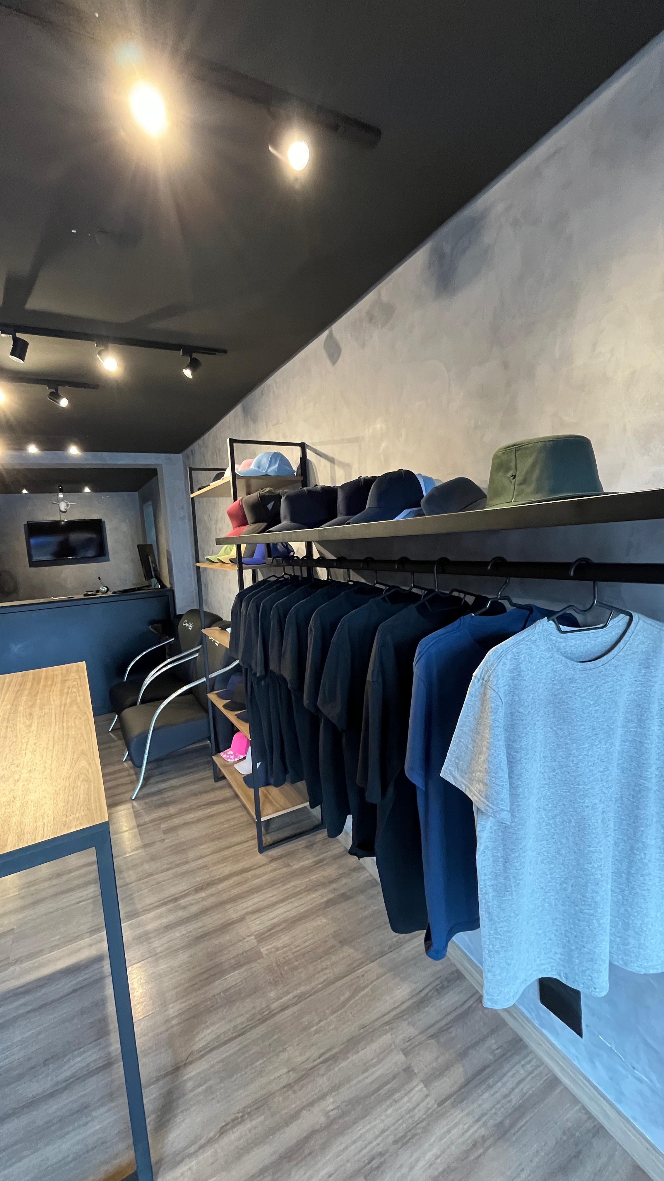 Entrada da loja com bonés e camisas